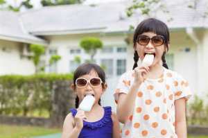 Senior citizen enjoying popsicle with grandchild outdoors