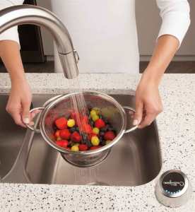 Water flowing into collander of vegetables